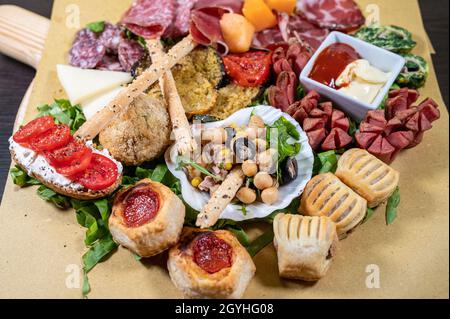 piatto di antipasti misti con salumi e legumi, formaggi, salse e snack Foto Stock