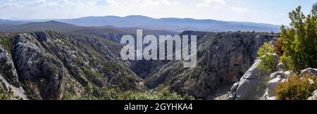 Veduta aerea del canyon di Krupa con la catena montuosa e il fiume sotto il cielo nuvoloso Foto Stock