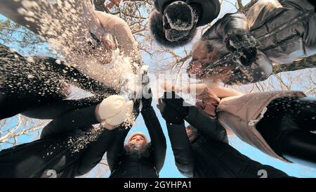 Le ragazze allegre gettano la neve mentre si levano in piedi in un cerchio. Foto Stock