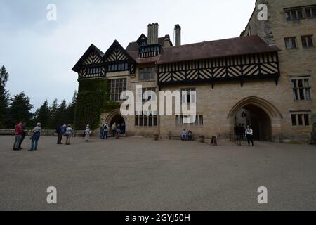 Cragside Northumberland National Trust casa ad arco ingresso persone vecchio edificio in pietra archi a frontalino in legno percorso elettrico stile strada vittoriano Foto Stock