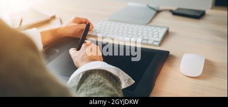 Le mani delle donne usano un tablet grafico con penna stilo e una moderna tastiera per computer per disegnare opere d'arte. Grafica, arti digitali o lavoro freelance Foto Stock