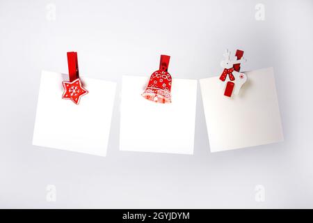 tre note di natale con clothespins rosso sullo sfondo. spazio di copia Foto Stock