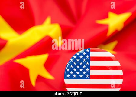 Il pulsante Stars and Stripes è contrassegnato dalla bandiera cinese gialla e rossa. Per la controversia USA-Cina, offshoring di lavoro USA alla Cina, metafora del Centro missione Cina degli Stati Uniti. Foto Stock