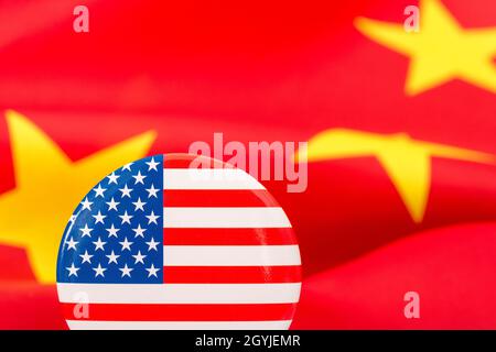 Il pulsante Stars and Stripes è contrassegnato dalla bandiera cinese gialla e rossa. Per la controversia USA-Cina, offshoring di lavoro USA alla Cina, metafora del Centro missione Cina degli Stati Uniti. Foto Stock