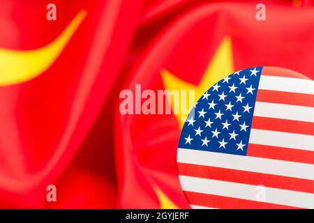 Il pulsante Stars and Stripes è contrassegnato dalla bandiera cinese gialla e rossa. Per la controversia USA-Cina, offshoring di lavoro USA alla Cina, metafora del Centro missione Cina degli Stati Uniti. Foto Stock