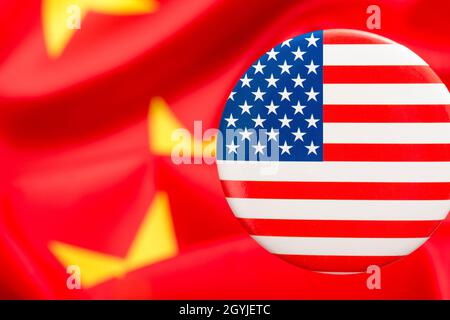 Il pulsante Stars and Stripes è contrassegnato dalla bandiera cinese gialla e rossa. Per la controversia USA-Cina, offshoring di lavoro USA alla Cina, metafora del Centro missione Cina degli Stati Uniti. Foto Stock