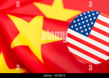 Il pulsante Stars and Stripes è contrassegnato dalla bandiera cinese gialla e rossa. Per la controversia USA-Cina, offshoring di lavoro USA alla Cina, metafora del Centro missione Cina degli Stati Uniti. Foto Stock