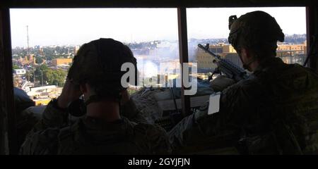 SGT. Kyle Jacob (a destra) un ingegnere di combattimento della prima squadra di combattimento di Brigata Stryker, 25esima divisione di fanteria e 2nd. Landon Montoya (a sinistra) prima squadra di combattimento di Brigata Stryker, 25esima divisione di fanteria guarda la folla protestando fuori di una sezione dell'Ambasciata degli Stati Uniti in Iraq a Baghdad, il 1 gennaio 2019. (US Army foto di SPC. Swanson) Foto Stock