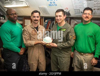 200101-N-WO152-1001 MARE ARABICO (DIC. 20, 2019) i marinai assegnati al 'dragon Slayers' di Helicopter Sea Combat Squadron (HSC) 11 celebrano il primo lancio in elicottero del decennio nella stanza pronta uno con una torta di Capt. Daniel prochazka, l'ufficiale esecutivo della portaerei USS Harry S. Truman (CVN 75), Nel Mar Arabico 1 gennaio 2020. Il Gruppo di Strike della portante di Harry S. Truman è schierato nell'area di 5th Fleet degli Stati Uniti delle operazioni di sostegno di operazioni navali per assicurare la stabilità e la sicurezza marittima nella regione centrale, collegando il Mediterraneo ed il Pacifico attraverso il w Foto Stock