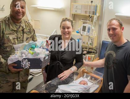 Il col. Claude Burnet, vice comandante, Landstuhl Regional Medical Center, consegna un cestino di regali a Sierra Duble e SPC. Sean Duble, uno specialista di tecnologia informatica con la sedicesima Brigata di sostegno, il 21° comando di sostegno del teatro, mentre celebrano l'arrivo del primo parto del bambino di LRMC nel 2020 con la nascita di una bambina da 8 libbre e 6 once, il 2 gennaio. Foto Stock