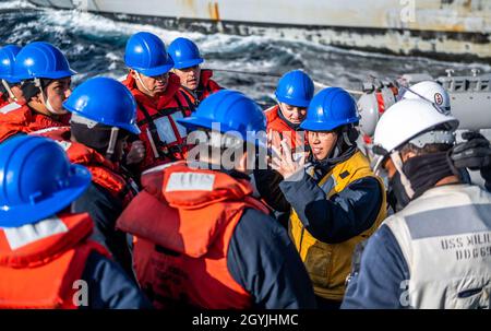 MARE DEL GIAPPONE (GEN. 5, 2020) Line Petty officer in carica, Cryptologic Technician (Technical) 3rd Class Alexis Maldonado, da Mays Landing, N.J., secondo da destra, debriefing il suo team seguendo le operazioni di line handling sul ponte missilistico di poppa del cacciatorpediniere missilistico guidato di classe Arleigh Burke USS Milius (DDG 69) Come la nave conduce un rifornimento-a-mare con il Henry J. Kaiser-classe in corso di rifornimento oliatore USNS John Ericsson (T-AO 194). Milius sta conducendo operazioni nella regione Indo-Pacific mentre è assegnato a Destroyer Squadron (DESRON) 15, il più grande schieramento a termine della Marina Foto Stock