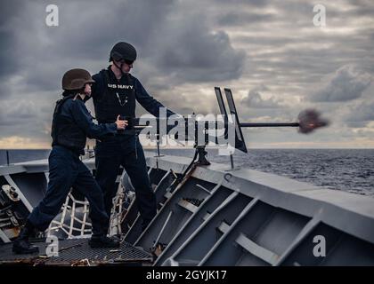 OCEANO PACIFICO (Gen. 07, 2020) Gunner’s Mate 2a Classe Austin Perry istruisce la Logistics Specialist 3a Classe Annette Hertz mentre spara una mitragliatrice del calibro di .50 durante l’addestramento delle armi a bordo dell’incrociatore missilistico guidato USS Chancellorsville di classe Ticonderoga (CG 62). Chancellorsville è schierata in avanti nella 7th Fleet area degli Stati Uniti di operazioni a sostegno della sicurezza e della stabilità nella regione Indo-Pacific. (STATI UNITI Foto Navy di Mass Communication Specialist 1a classe Jeremy Graham) Foto Stock