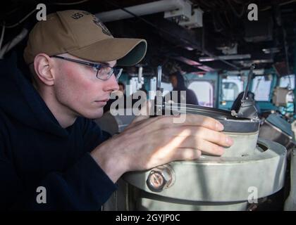 200108-N-VP266-1008 MAR MEDITERRANEO (GEN. 8, 2020) Ensign Brandon Watson, assegnato alla nave di sbarco anfibio Harpers Ferry-Class USS Oak Hill (LSD 51), cerca i contatti mentre si guarda in piedi sul ponte a bordo di Oak Hill, 8 gennaio 2020. Oak Hill, con sede a Joint Expeditionary base (JEB) Little Creek-Fort Story, Virginia, opera nell'area delle operazioni della 6a flotta statunitense a sostegno degli interessi di sicurezza nazionale degli Stati Uniti in Europa e Africa. (STATI UNITI Foto Navy di Mass Communication Specialist terza classe Griffin Kersting/rilasciato) Foto Stock