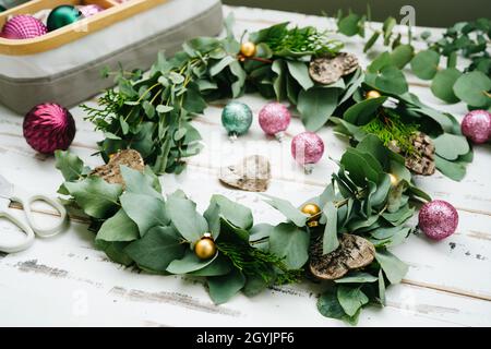 Corona di eucalipto verde su tavola di legno bianco Foto Stock