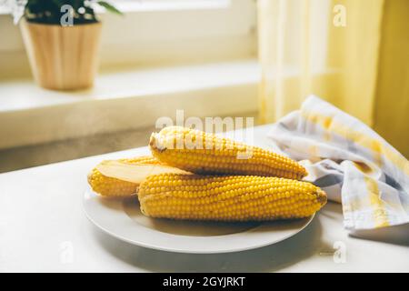 Pannocchie calde di mais appena cotte in un piatto Foto Stock