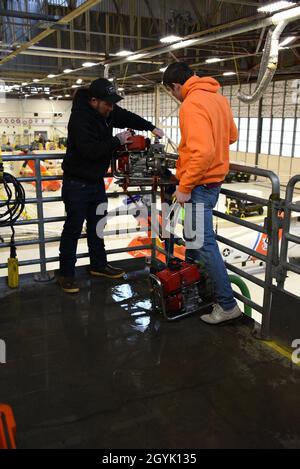 Due pescatori commerciali pratica tecniche adeguate per il funzionamento della pompa di de-annaffiatura alla base della Guardia Costiera Kodiak, Alaska, 11 gennaio 2020. Ufficiale di Petty prima classe Andrew Stover, un tecnico di sopravvivenza dell'aviazione, ha trascorso il pomeriggio scambiando fuori i segmenti di formazione con un istruttore dell'Associazione di formazione di sicurezza marina dell'Alaska (AMSEA), Art Schultz, per rinfrescare i pescatori sulle tecniche usate per mitigare i pericoli in mare. Foto della Guardia Costiera degli Stati Uniti di Petty Officer 3a Classe Lauren Dean. Foto Stock