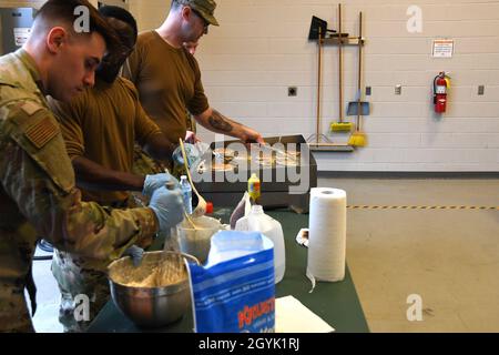 North Carolina Air National Guardsmen cuoco le frittelle su una griglia durante una raccolta di fondi per la colazione, 12 gennaio 2020 al 235th Air Traffic Control Squadron a New London, N.C. I membri della Guardia Nazionale aerea del North Carolina, nonché le autorità aeroportuali locali e le forze dell'ordine sono stati invitati a partecipare a una colazione sociale pancake al fine di rafforzare i legami con la comunità e costruire nuove relazioni, raccogliendo fondi per morale, benessere e ricreazione. Foto Stock