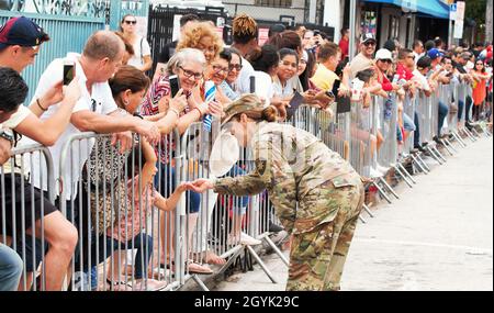 SGT. Frances Virella un soldato assegnato alla Società della sede Centrale del 50th Regional Support Group (RSG) scuote le mani con i residenti di Miami allineati lungo il percorso Three Kings Day Parade nel quartiere Little Havana di Miami. I soldati e i veicoli del 50° RSG hanno partecipato alla Parata dei tre Re come parte delle iniziative di copertura della comunità della Guardia Florida nell'area meridionale della Florida. Foto Stock