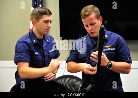 Kevin Hoeben, ufficiale di Petty, terza classe, esamina il funzionamento del fucile con Petty Officer, prima classe, Darryl Blackall durante l'addestramento alla stazione aerea della Guardia Costiera, Clearwater, Florida Martedì, Gennaio 14, 2020. Le missioni di polizia e di sicurezza della Guardia Costiera richiedono competenze tecniche e la capacità di esprimere giudizi rapidi. I membri tengono aggiornate le proprie certificazioni con una formazione regolare sulle armi e sull'uso giudicante della formazione sulla valutazione della forza. Foto Stock