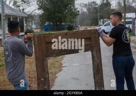 Volontari marini con il Marine Corps Air Station Cherry Point Single Marine Program (SMP) ripuliscono i detriti durante un evento volontario a Pollocksville, North Carolina, 15 gennaio 2020. I Marines passarono la giornata pulendo i detriti dai cortili e dai tetti delle case che furono colpite da gravi inondazioni durante l'uragano Firenze. Questo evento volontario è solo uno dei tanti che l'SMP ospita per restituire alle comunità circostanti. (STATI UNITI Foto del corpo marino di CPL. Andrew King) Foto Stock