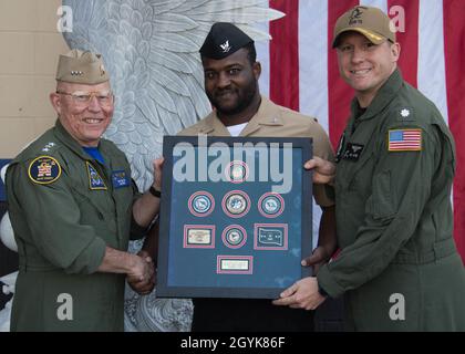 CORONADO, California (Gen. 15, 2020) Vice ADM. DeWolfe Miller, comandante, Naval Air Forces e CDR. Eric Hutter, comandante, Helicopter Maritime Strike Squadron 78 (HSM 78) presenta la terza classe di Yeoman John Norman con il Premio membro dell'anno del servizio dell'organizzazione di servizio unita (USO). Norman è stato selezionato come membro dell'anno del Servizio USO della Marina dopo aver intervistato in una situazione di violenza domestica che ha visto iniziare mentre era fuori servizio. U.S. Navy Photo by Mass Communication Specialist 2a Classe Chelsea D. Meiller (rilasciato) 200115-N-GR718-0040 Foto Stock