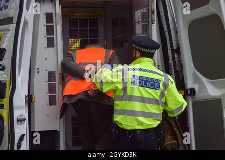 Londra, Regno Unito. 08 ottobre 2021. La polizia rimuove e arresta un attivista britannico insulato che si è incollato alla strada durante la protesta alla rotonda di Old Street.i manifestanti britannici insulati chiedono che il governo isoli tutte le abitazioni sociali entro il 2025, E si assume la responsabilità di garantire che tutte le case nel Regno Unito siano più efficienti dal punto di vista energetico entro il 2030, come parte di più ampi obiettivi di cambiamento climatico e decarbonizzazione. Credit: SOPA Images Limited/Alamy Live News Foto Stock