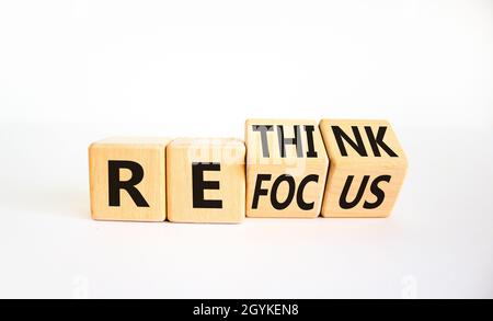 Rifocalizzazione e ripensamento del simbolo. L'uomo d'affari ha girato i cubi e ha cambiato la parola 'focus' in 'ripensare'. Bella tavola bianca, sfondo bianco. Business re Foto Stock