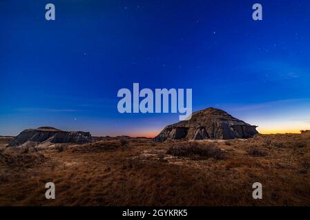 L'intera gamma di stelle e costellazioni dell'inverno settentrionale, tra cui Orion, si trova al crepuscolo serale al Dinosaur Provincial Park, Alberta, ON Foto Stock