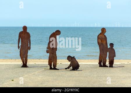 La silhouette in acciaio rappresenta una vacanza in famiglia sul lungomare di Colwyn Bay Foto Stock