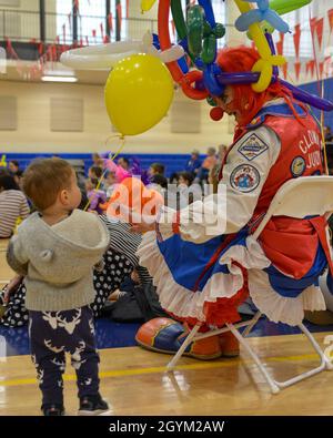 Un clown parla con uno dei bambini che guardano un circo durante il Circo MWR e la Scuola che si tiene all'interno del Centro Fitness presso il Naval Support Activity Bethesda, 25 gennaio 2020. (STATI UNITI Foto Navy di Mass Communication Specialist 2a Classe Julio Martinez Martinez) Foto Stock