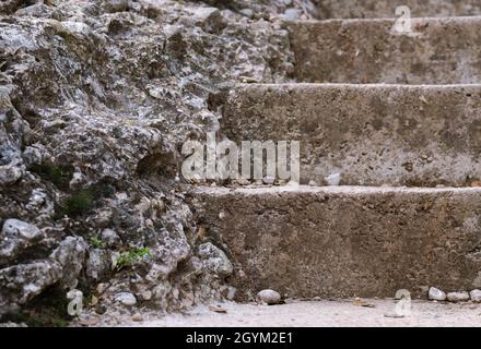 Scala di pietra nella montagna. Varie rocce. Varie rocce sciolte lungo il gradino nella scalinata di pietra Foto Stock