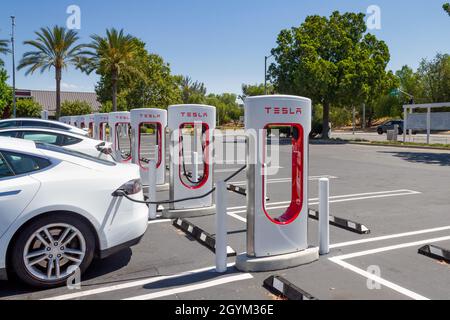 Brea, CA, USA – 1° agosto 2021: Ricarica di una Tesla bianca presso la stazione Supercharger Tesla al centro commerciale Brea di Brea, California. Foto Stock