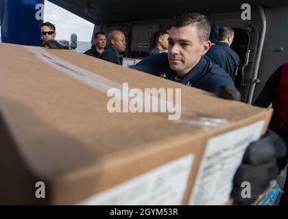 GOLFO ARABO (Gen. 27, 2020) - specialista logistica prima classe Bradley rash rimuove una scatola da un pallet per passare lungo al gruppo di lavoro a bordo del cacciatorpediniere missilistico guidato USS Carney (DDG 64) durante un rifornimento-in-mare con il rifornimento di flotta Oiler USNS Walter S. Diehl (T-AO-193), 27 gennaio 2020. Carney è schierata nella 5th Fleet area degli Stati Uniti di operazioni a sostegno delle operazioni navali per garantire la stabilità e la sicurezza marittima nella regione centrale, collegando il Mediterraneo e Pacifico attraverso l'Oceano Indiano occidentale e tre punti di arresto strategici. (STATI UNITI Foto Navy di Mass Comm Foto Stock