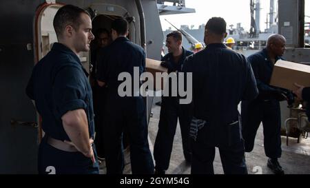 GOLFO ARABO (Gen. 27, 2020) - il Lt. John Buergers, responsabile della fornitura a bordo del cacciatorpediniere missilistico guidato USS Carney (DDG 64), supervisiona un gruppo di lavoro che si occupa della movimentazione del carico da un rifornimento in mare con l'oliatore di rifornimento della flotta USNS Walter S. Diehl (T-AO-193), 27 gennaio 2020. Carney è schierata nella 5th Fleet area degli Stati Uniti di operazioni a sostegno delle operazioni navali per garantire la stabilità e la sicurezza marittima nella regione centrale, collegando il Mediterraneo e Pacifico attraverso l'Oceano Indiano occidentale e tre punti di arresto strategici. (STATI UNITI Foto Navy di Mass Communication Specialist 1st Class Fre Foto Stock