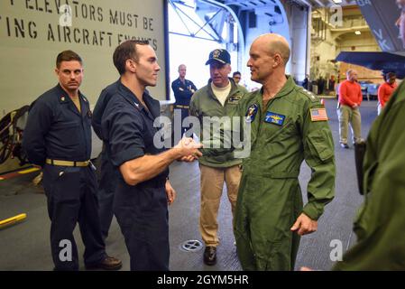 200129-N-MB038-1029 MAR DELLE FILIPPINE (GEN. 29, 2020) Vice ADM. Bill Merz, comandante, US 7a flotta, tour la baia di hangar della nave d'assalto anfibio USS America (LHA 6). L'America, ammiraglia dell'America Expeditionary Strike Group, 31st Marine Expeditionary Unit team, opera nell'area operativa della 7a flotta statunitense per migliorare l'interoperabilità con alleati e partner e fungere da forza di reazione pronta a difendere la pace e la stabilità nella regione IndoPacifico. (STATI UNITI Foto Navy di Mass Communication Specialist 2a classe Christopher Marshall) Foto Stock