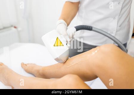 Rimozione laser dei capelli delle gambe femminili da vicino Foto Stock