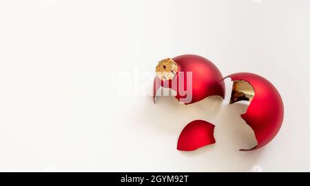 Natale bauble rotto isolato su sfondo bianco, vista closeup. La palla rossa di Natale si è schiantata a pezzi. Incidente di vacanza, fragilità, rabbia concetto Foto Stock