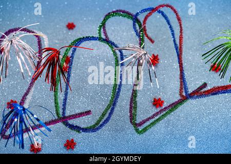 Cartolina di Capodanno 2022 con numeri brillanti e colorati realizzati con pulitori per tubi o lavafischietti, sfondo turchese brillante con stelle rosse festive. Foto Stock