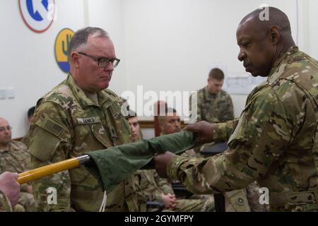 Il col. Martin Danks, a sinistra, e il Maestro Sgt. William Wall, 618esimo distacco del Quartermaster, scompaia i colori della loro unità durante il 320/618esimo distacco del Quartermaster cerimonia di autorità a Camp Arifjan, Kuwait, 2 febbraio 2020. (STATI UNITI Foto della riserva dell'esercito da SPC. Dakota Vanidestine) Foto Stock