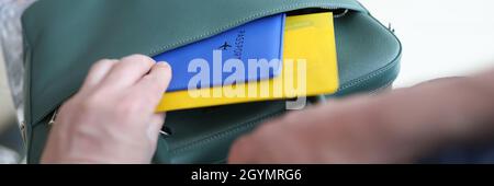 Uomo che mette i biglietti dell'aereo e il passaporto in valigia closeup Foto Stock