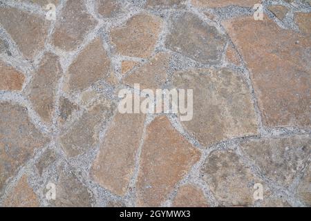 Superficie stradale arancione in pietra. Trama senza giunture. La tessitura di una strada di pietra. Foto di alta qualità Foto Stock