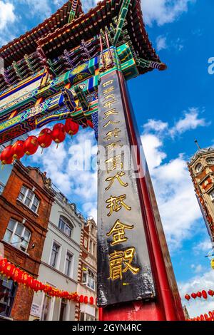 Iscrizione su un cancello colorato in Chinatown a sera, Londra, Regno Unito Foto Stock