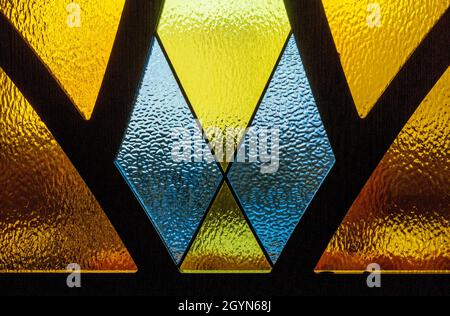 Vetro verniciato a rilievo con sezioni separate in metallo. Forme geometriche con vetro colorato Foto Stock