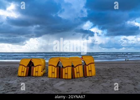 Fine della stagione sulla spiaggia, nuvole tempesta scura, mare mosso, autunno sul Mare del Nord in Olanda del Nord, vicino alla città di Egmond aan Zee, sedie da spiaggia Foto Stock