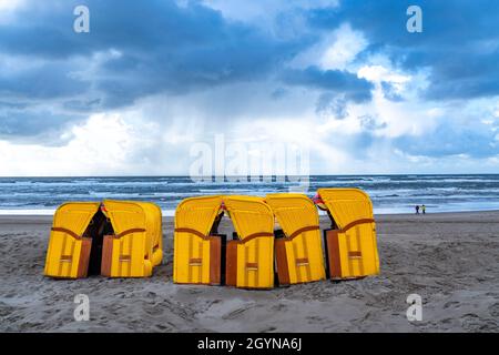 Fine della stagione sulla spiaggia, nuvole tempesta scura, mare mosso, autunno sul Mare del Nord in Olanda del Nord, vicino alla città di Egmond aan Zee, sedie da spiaggia Foto Stock