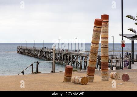 I piloni d'arte sul litorale di Port Noarlunga con il molo sfocato selettivamente il 28 settembre 2021 Foto Stock