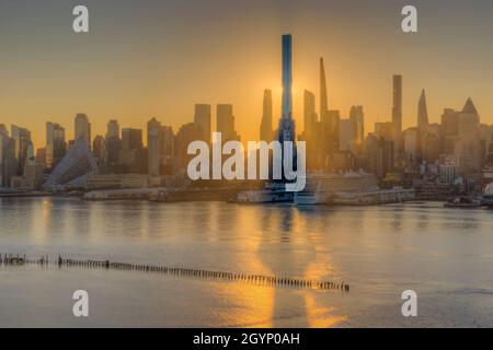 Central Park Tower, un grattacielo residenziale sulla 57th Street, proietta un'ombra sull'Hudson all'alba a New York City. Foto Stock