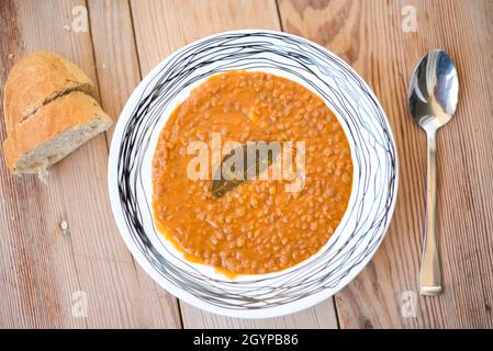 Zuppa di lenticchie o lenticchie, cibo tradizionale greco, su un piatto su un tavolo di legno Foto Stock