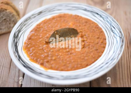 Zuppa di lenticchie o lenticchie, cibo tradizionale greco, su un piatto su un tavolo di legno Foto Stock