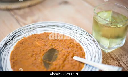 Zuppa di lenticchie o lenticchie, cibo tradizionale greco, su un piatto su un tavolo di legno Foto Stock